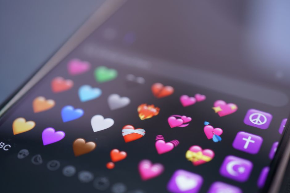 Close-up of colorful heart emojis displayed on a smartphone screen, representing digital communication.